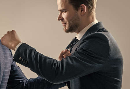 Manager have fist fight with male adult in formal wear grey background, fist-fighting
