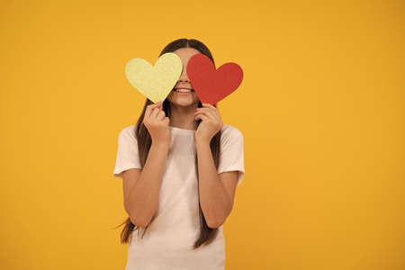 be my valentine. teen girl on yellow background. love present. positive kid with love romantic giftの写真素材