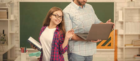 cropped father and happy child study at school with book and laptop on blackboard background, schoolの写真素材