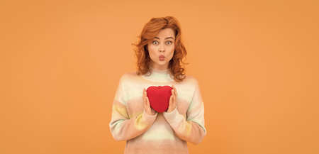 funny redhead woman with red heart on orange background. valentinesの写真素材