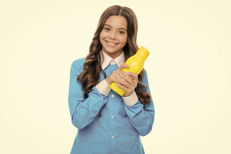 Happy child hold yellow plastic bottle with vegetarian liquid food for breakfast, smoothieの写真素材