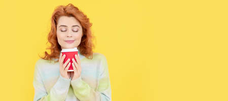 Woman isolated face portrait, banner with copy space. happy redhead woman smelling takeaway coffee...