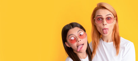 Mother and daughter child banner, copy space, isolated background. happy family portrait of single mother and daughter in glasses showing tongue, fun tongue crazy.の写真素材