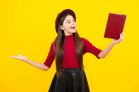 Teen girl pupil hold books, notebooks, isolated on yellow background, copy space. Back to school,...