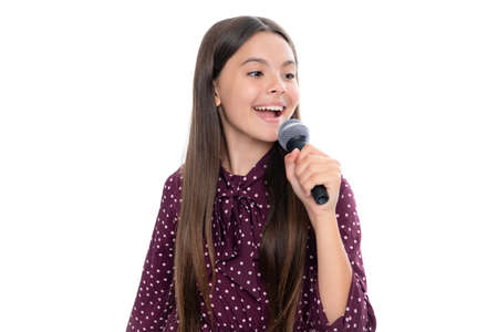 Kid singing. Emotional amazed teen girl with microphone singing against white background. Singing lovely singer girl hold microphone.の写真素材