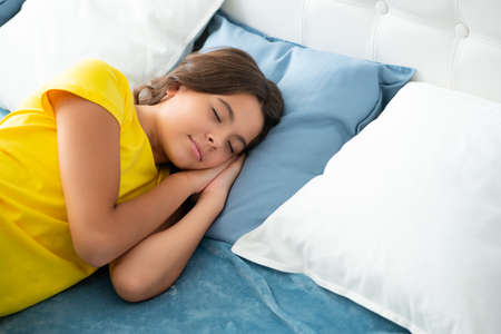 Sleeping and dreaming kids. Kid lying and sleeping on bed. Child teen sleeps in the bed. Sleeper, napping concept.の写真素材
