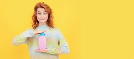 happy redhead woman with curly hair using shampoo or conditioner, hair wash. Woman isolated face...