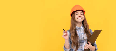 builder kid write in folder. building and construction. happy child worker wear hardhat. Child in hard hat horizontal poster design. Banner header, copy space.の写真素材