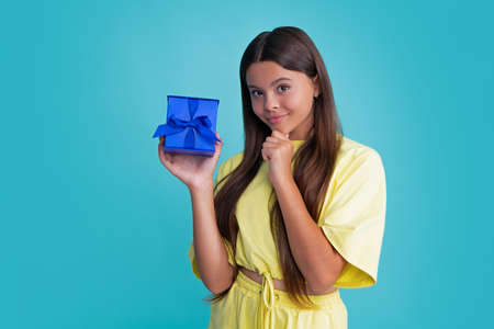 Child with gift present box on isolated background. Presents for birthday, Valentines day, New Year or Christmas. Happy girl face, positive and smiling emotions.の写真素材
