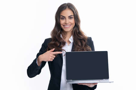 Beautiful smiling business woman over grey background using laptop computer. Woman holding laptop with empty mock up screen for copy space.の写真素材