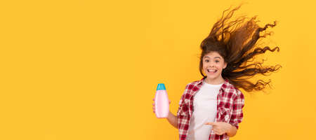 kid use shower gel. happy teen girl with shampoo bottle. shampooing hair in salon. Banner of child...