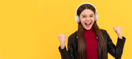 listen to music. wireless headset device accessory. new technology. Child portrait with headphones, horizontal poster. Girl listening to music, banner with copy space.の写真素材