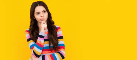 Thoughtful teenager girl touch chin and thinking, pensive child making idea. Child face, horizontal poster, teenager girl isolated portrait, banner with copy space.の写真素材