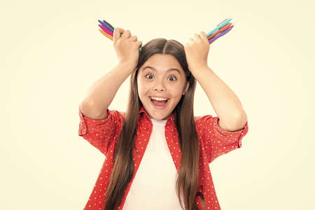 Funny school girl with colorful pencils isolated on white background. Portrait of happy smiling...