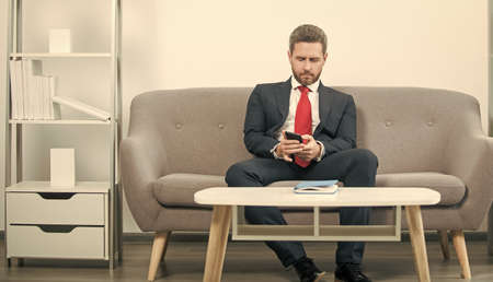 businessman sitting in office and chat on phone