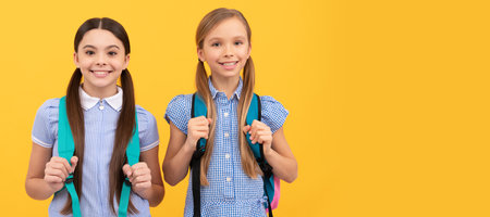 School girls friends. Happy children back to school on Knowledge day September 1 yellow background....