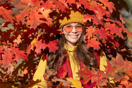 Teen child girl on autumn fall leaves background. smiling kid in sunglasses at autumn leaves on...