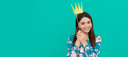 Happy girl princess smile holding prop crown blue background, prom. Child queen princess in crown...