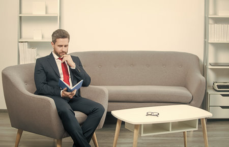 mature businessman in suit sit in office with plannerの写真素材