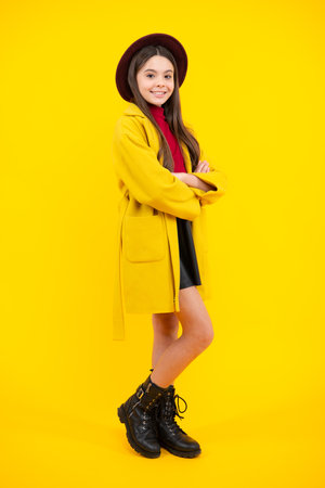 Elegant fashion teenager child girl posing in studio. Trends kids clothes. Happy teenager portrait. Autumn clothes.の写真素材
