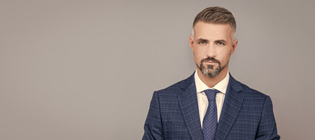 Man face portrait, banner with copy space. Business man in suit, isolated studio background.の写真素材