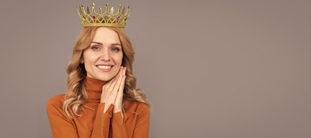 cheerful blonde woman with curly hair wear crown, glory. Woman portrait, isolated header banner with copy space.の写真素材