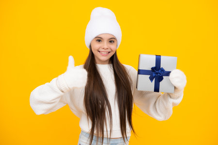 Emotional teenager child hold gift on birthday. Funny kid girl holding gift boxes celebrating happy New Year or Christmas.の写真素材