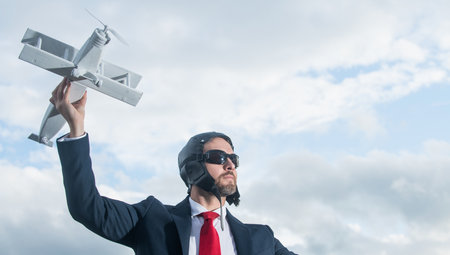 businessman in suit and pilot hat launch plane toy. imagination