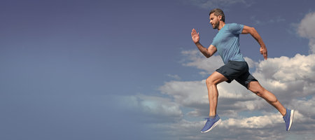 Man running and jumping, banner with copy space. healthy sportsman with muscular body running in sportswear outdoor on sky background, sportの写真素材