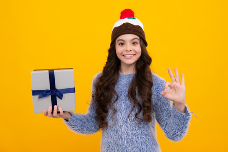 Child with gift present box on isolated background. Presents for birthday, Valentines day, New Year or Christmas. Happy teenager, positive and smiling emotions of teen girl.の写真素材