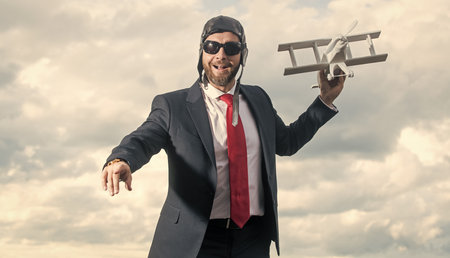 businessman in suit and pilot hat launch plane toy. business aimの写真素材