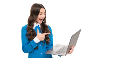 surprised child long curly hair pointing finger on laptop isolated on white, school blog. School...