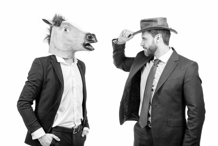 Cowboy man and businessman in horse head mask on costume party, corporate Halloweenの写真素材
