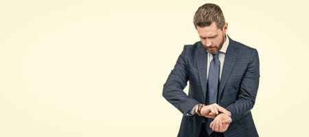 Businessman in business suit place fingers on wrist measuring heartbeat with watch, pulse rate. Man face portrait, banner with copy space.の写真素材