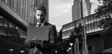 concentrated freelance man post blog online. businessman using laptop for blogging.の写真素材