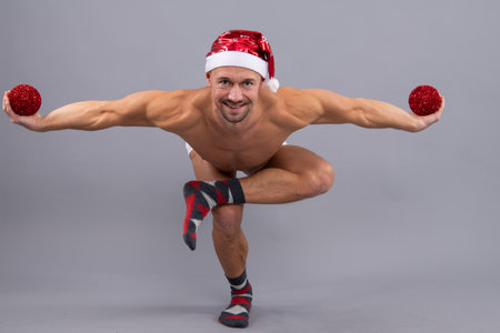 Crazy santa. Naked gay santa in santa head funny yaga posing on gray studio background.の写真素材