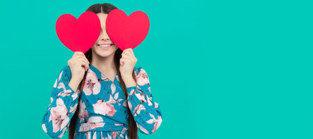 smiling child hold red heart symbol of love for valentines day, valentine. Kid girl portrait with heart love symbol, horizontal poster. Banner header with copy space.の写真素材