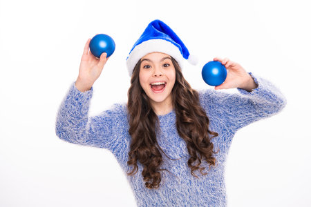 Winter teen girl hold christmas balls. Portrait photo of happy young female teenager in winter sweater isolated over white background.の写真素材
