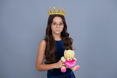Birthday kids prom party. Little queen wearing golden crown. Teenage girl princess holding crown tiara. Prom party, childhood concept.の写真素材
