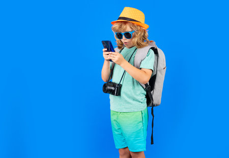Traveler tourist kid boy 7-8 years old. Kid boy with mobile phone.