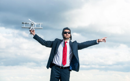 businessman in suit and pilot hat launch plane toy on sky background. challengeの写真素材