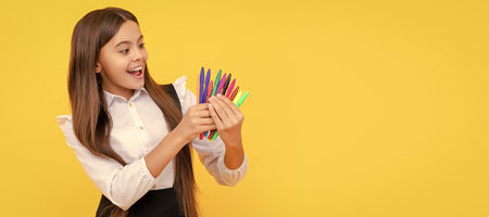 Happy girl child hold felt-tips yellow background, school stationery. Banner of school girl student....