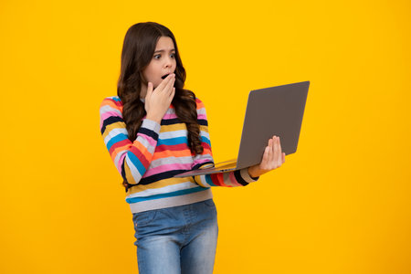 Young student school girl, studying with laptop computer. E-learning concept. Shocked amazed face,...