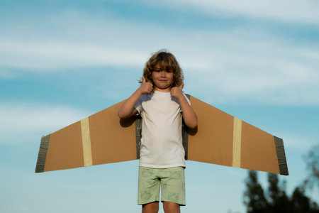 Child boy toddler playing with toy airplane and dreaming future. Happy boy pilot play with airplane outdoors.の写真素材