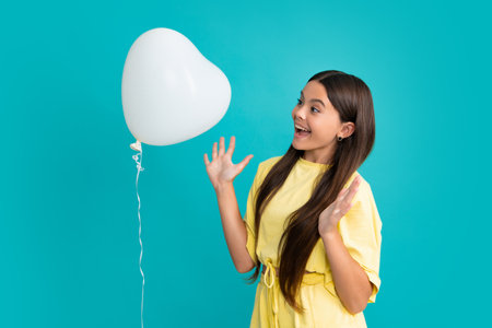 Portrait of child teenage girl with heart balloon. Valentines day concept. Excited face, cheerful...