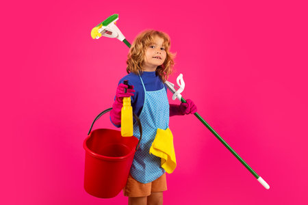 Portrait of child cleaning, concept growth, development, family relationships. Housekeeping and home cleaning concept. Child use duster and gloves for cleaning. Studio isolated background.の写真素材