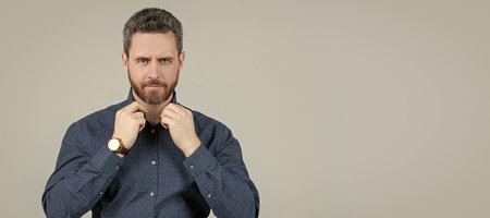 Looking effortlessly smart. Unshaven man button shirt grey background. Wearing smart casual. Man face portrait, banner with copy space.の写真素材