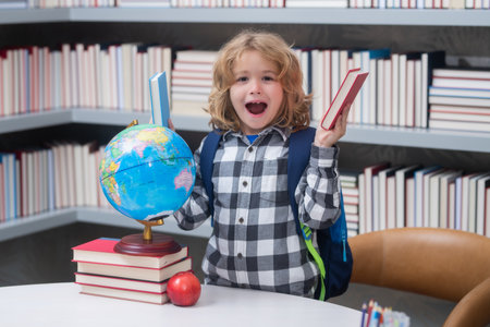 Excited pupil. Back to school. Funny little boy from elementary school with book. Education.