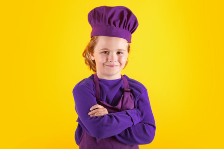 Kid chef cook, studio portrait. Children cooking. Kid boy with apron and chef hat.の写真素材