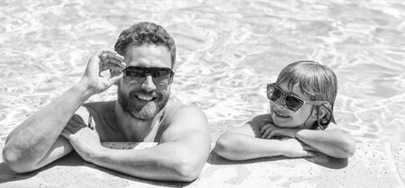 happy family of daddy and son having fun in summer swimming pool, vacationの写真素材